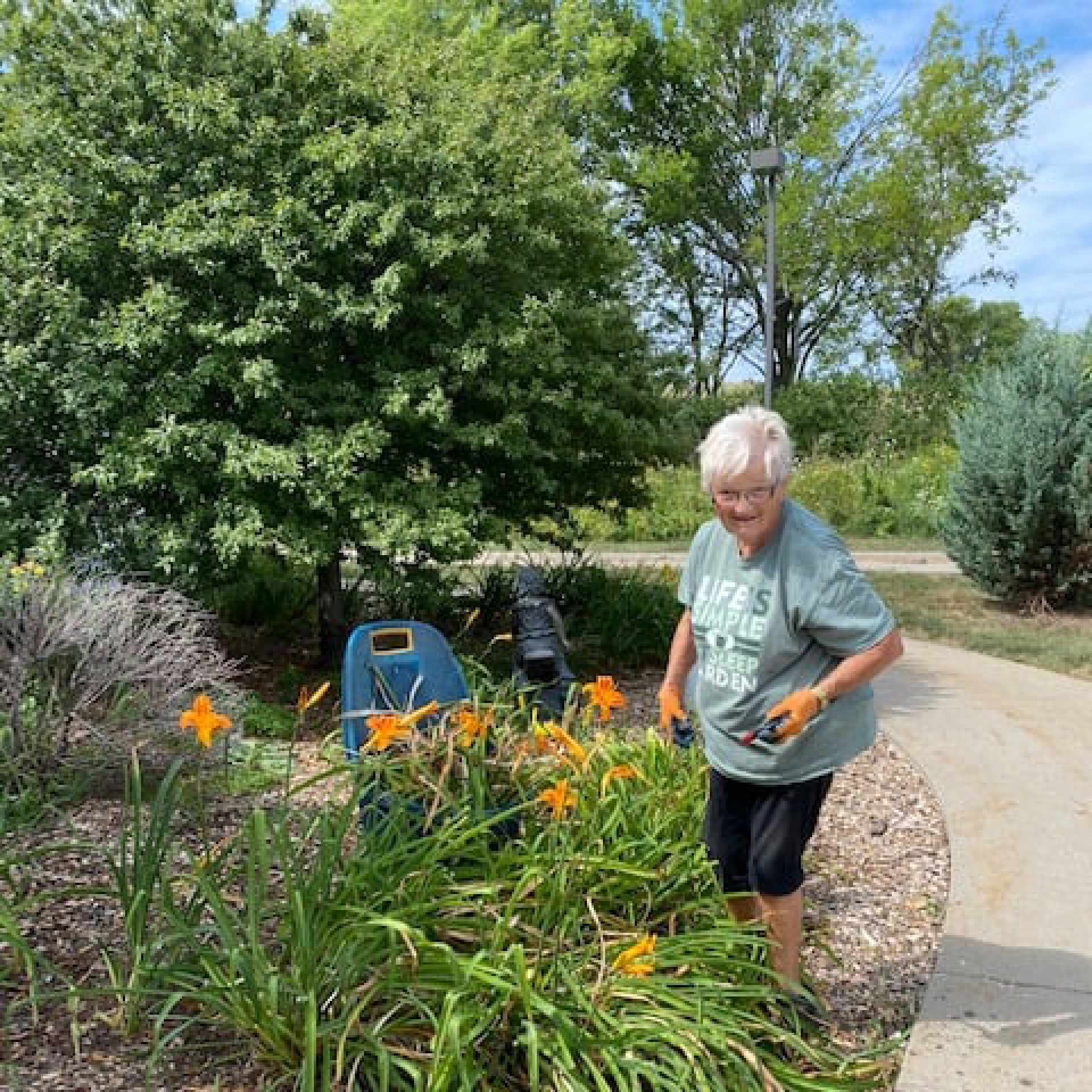 Woman gardening amongst flowers at Iowa River Hospice.